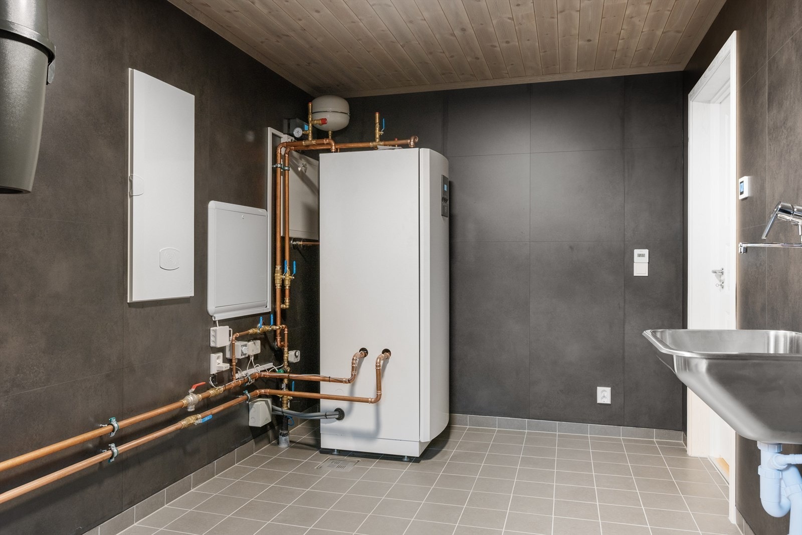 Vaskerommet/teknisk rom har plater på vegg og flislagt gulv. Galleribilde