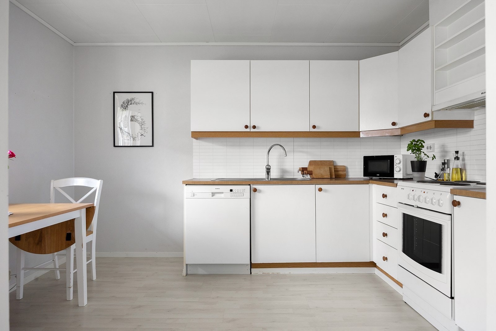 Det lyse kjøkkenet er utstyrt med slette fronter og laminat benkeplate med nedfelt vask. Kjøkkenet har fine arbeidsforhold og praktiske løsninger, og inkluderte hvitevarer gjør det klart til å tas i bruk. Galleribilde