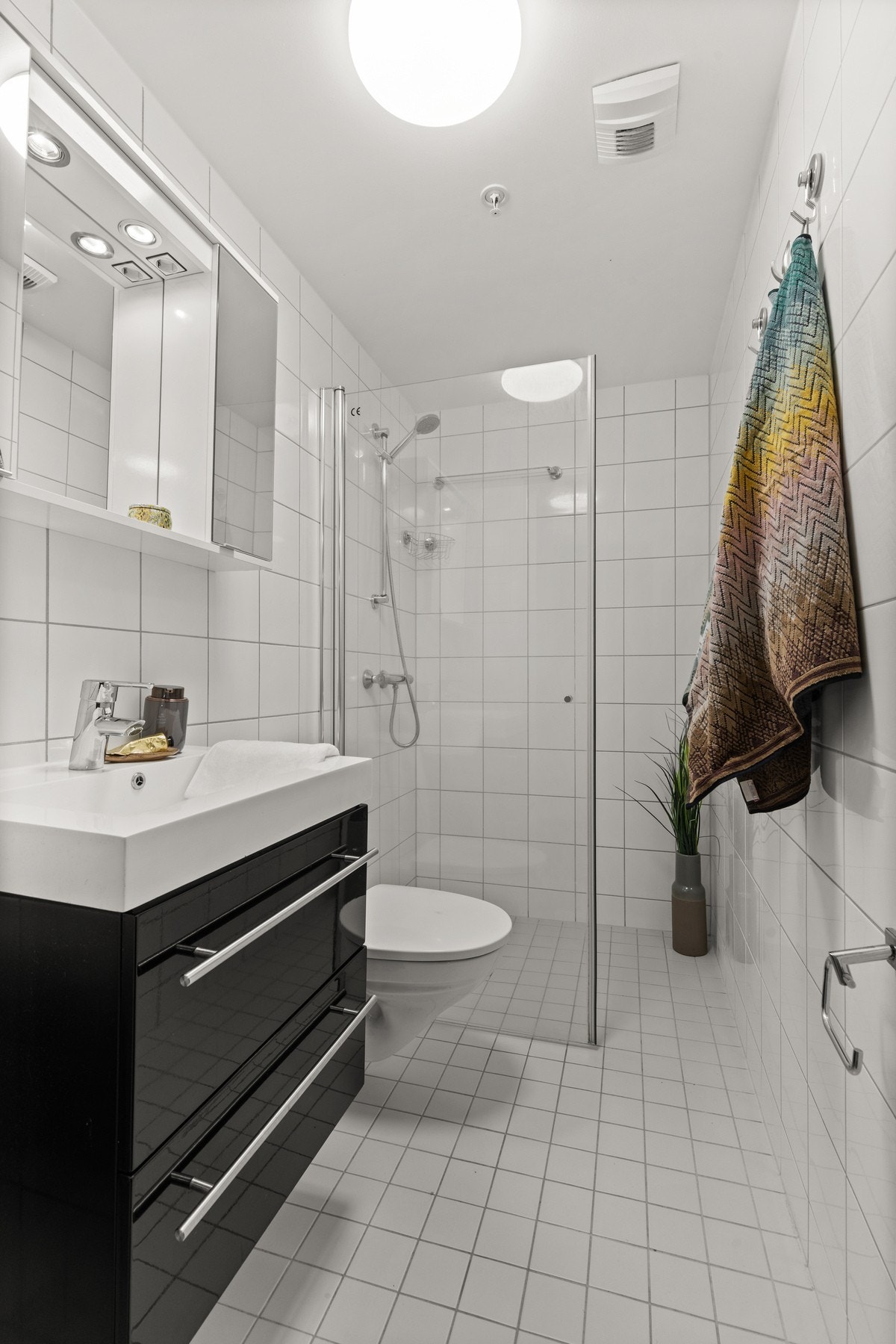 Bad 2 utstyrt med styrt med dusj med innfellbare glassvegger, servantseksjon med skuffer og heldekkende vask, speilskap med lys og vegghengt wc. Galleribilde