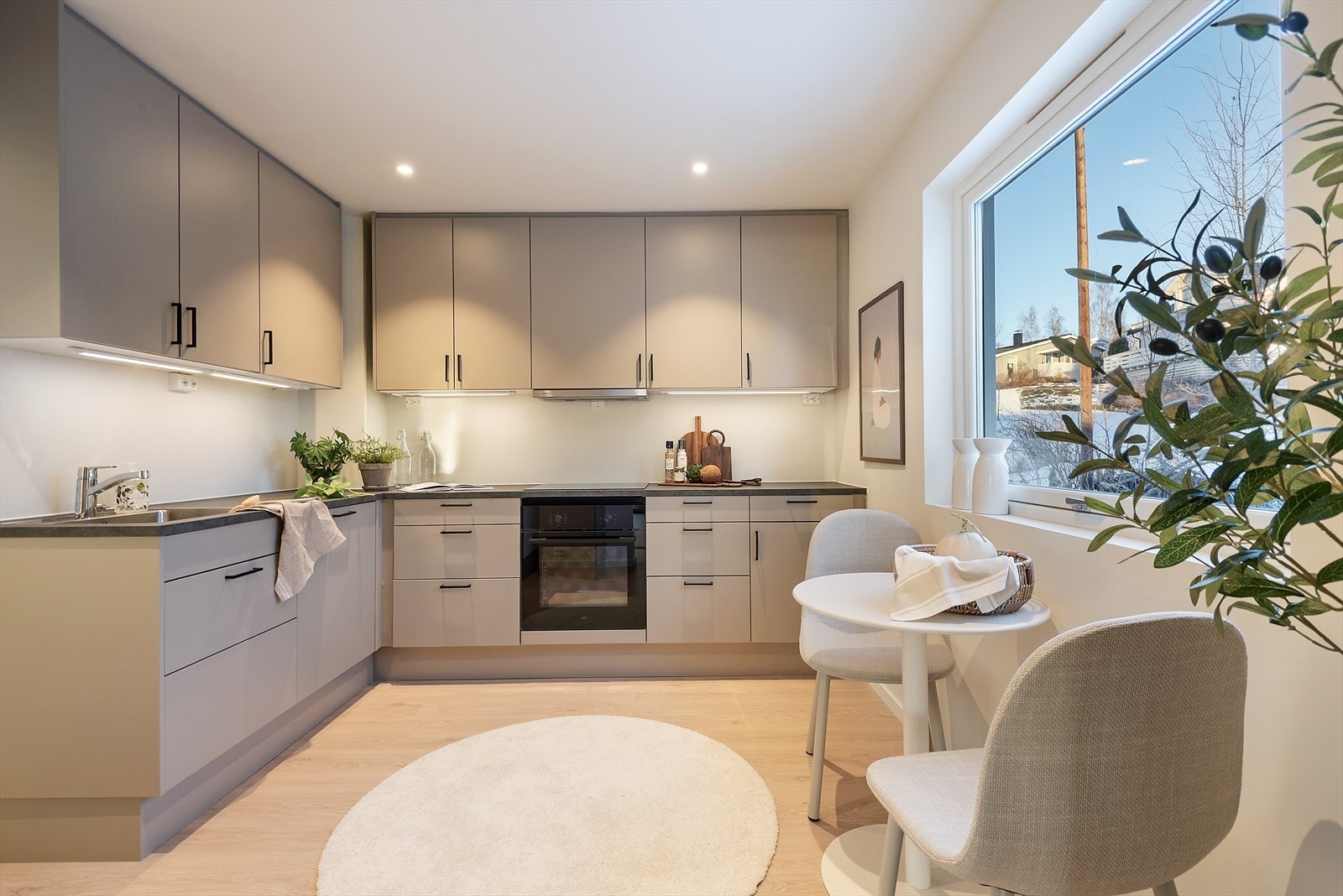 Lekkert kjøkken med innredning i vinkel. Galleribilde