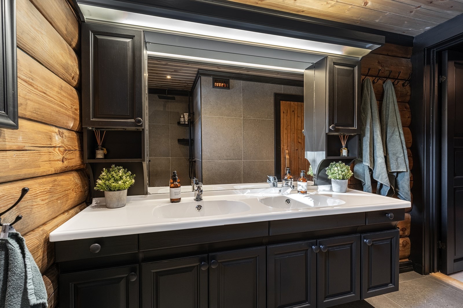 Lekkert baderom i lune farger perfekt for en tømmerhytte. Galleribilde