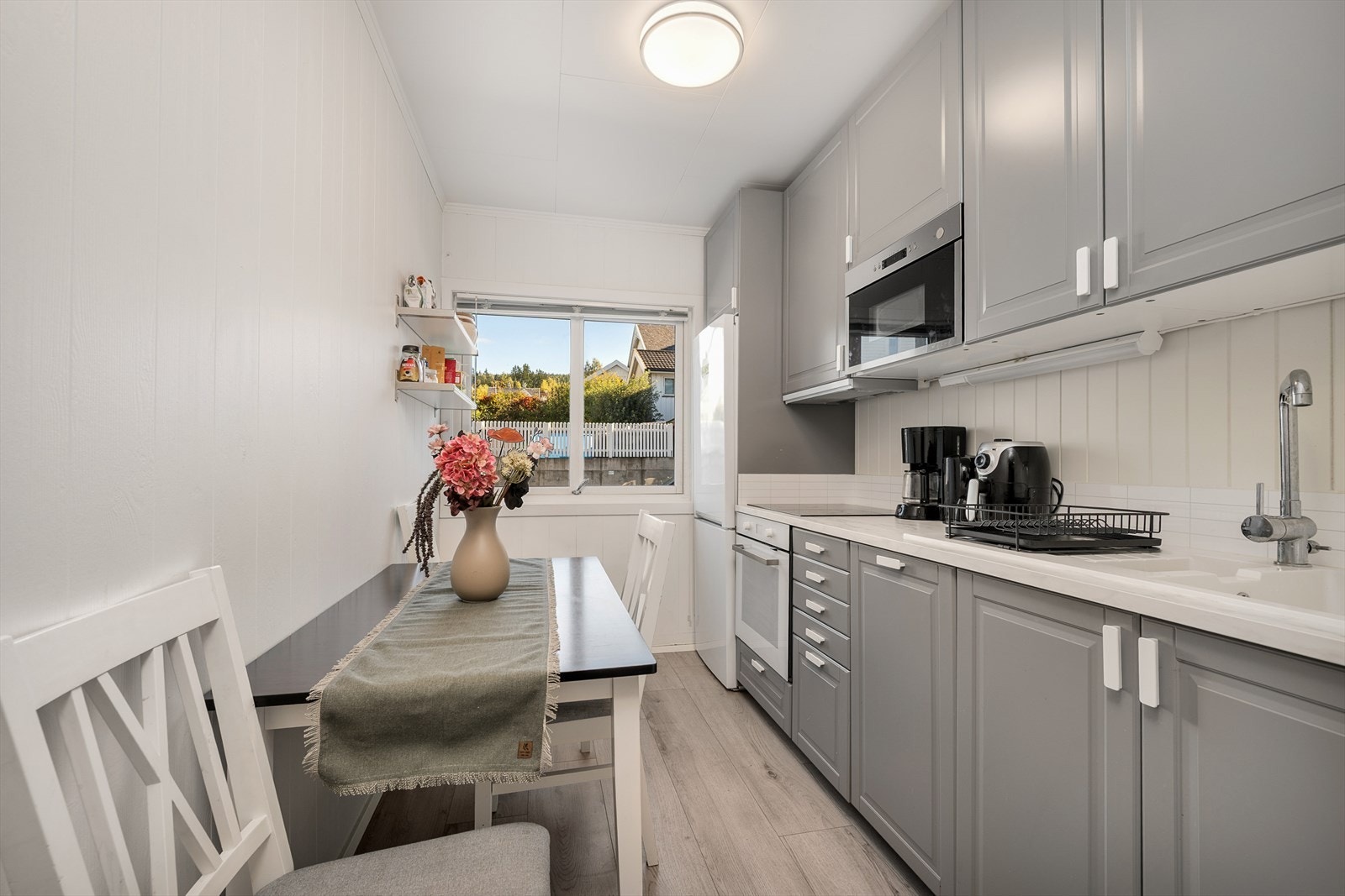 Kjøkkeninnredning med over- og underskap med profilerte fronter og laminert benkeplate Galleribilde