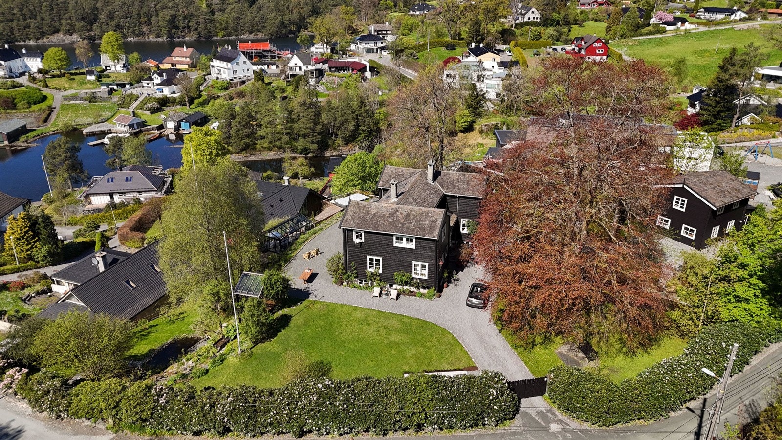 Bak en rhododenronhekk og en høy port befinner det seg en eiendom uten sidestykke Galleribilde