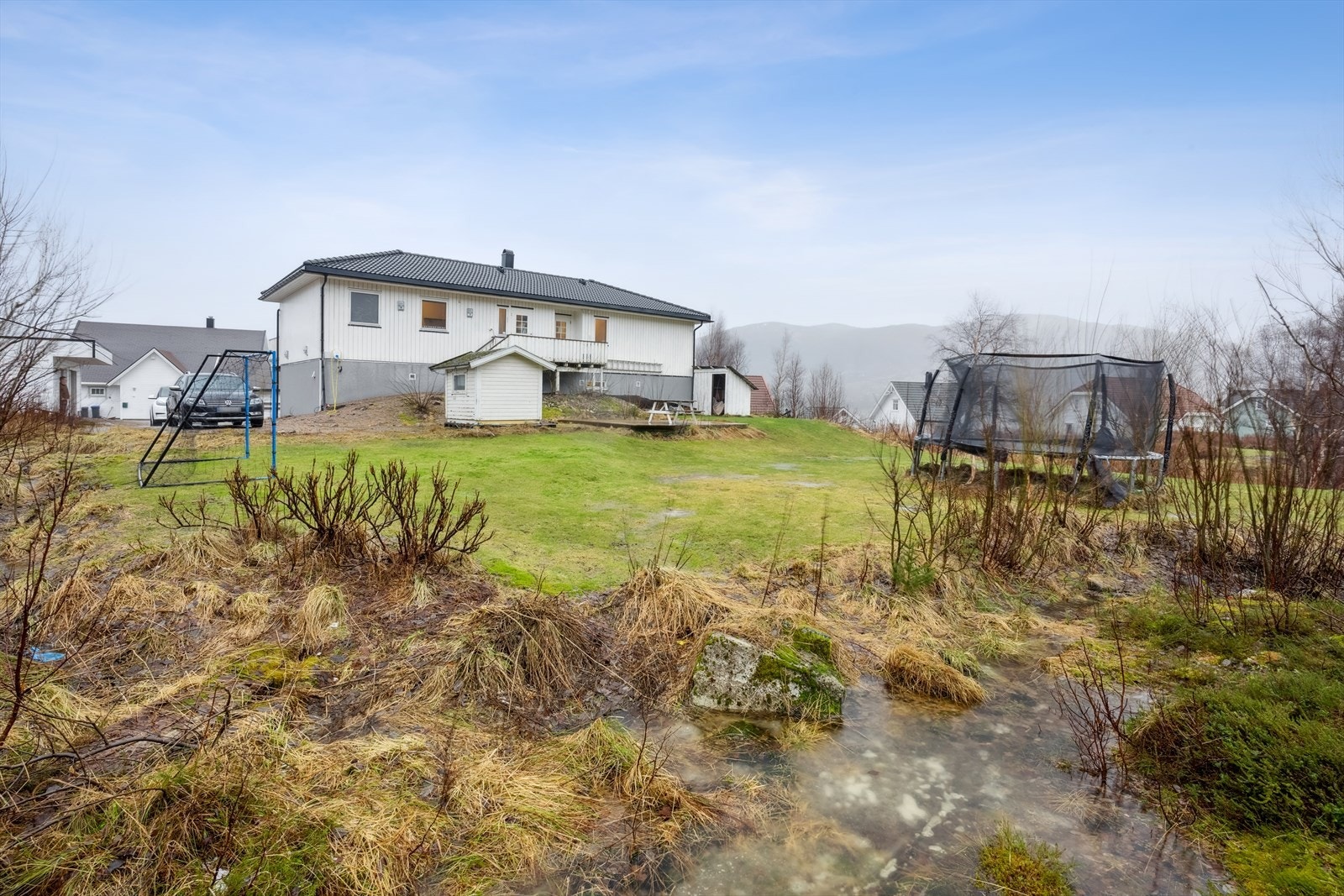 Romslig ende tomt, opparbeidet med plen og diverse prydbusker. Galleribilde