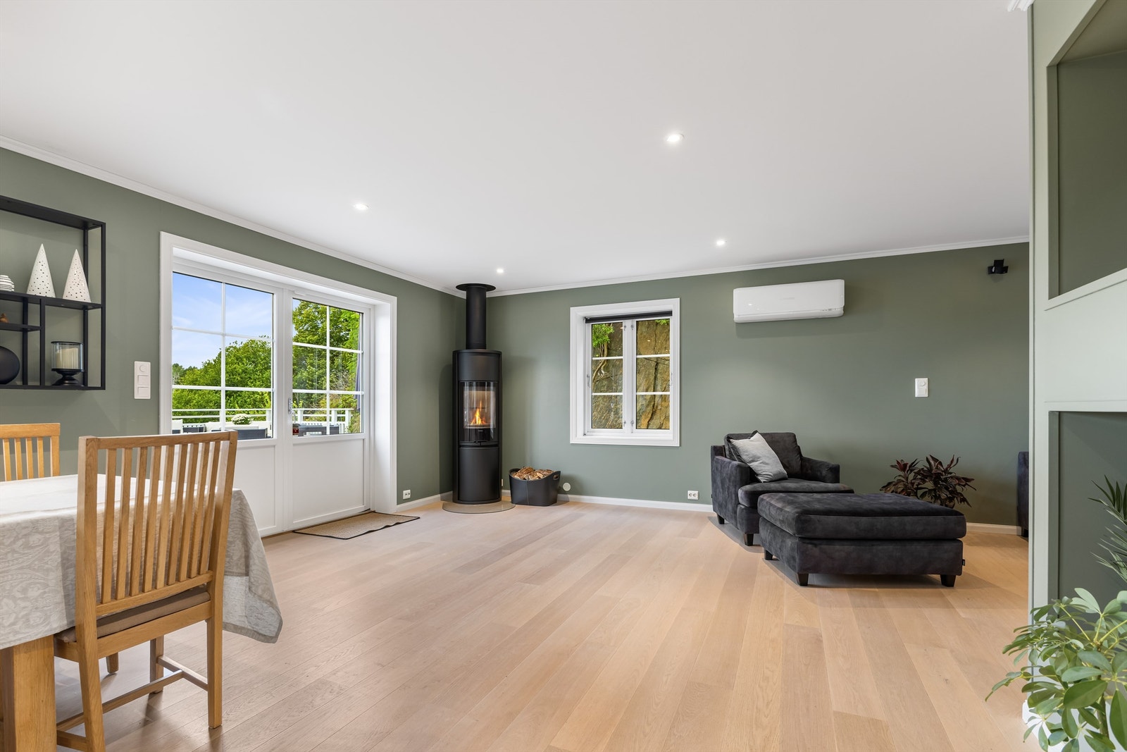 Stue med varmepumpe, peisovn og utgang til veranda Galleribilde