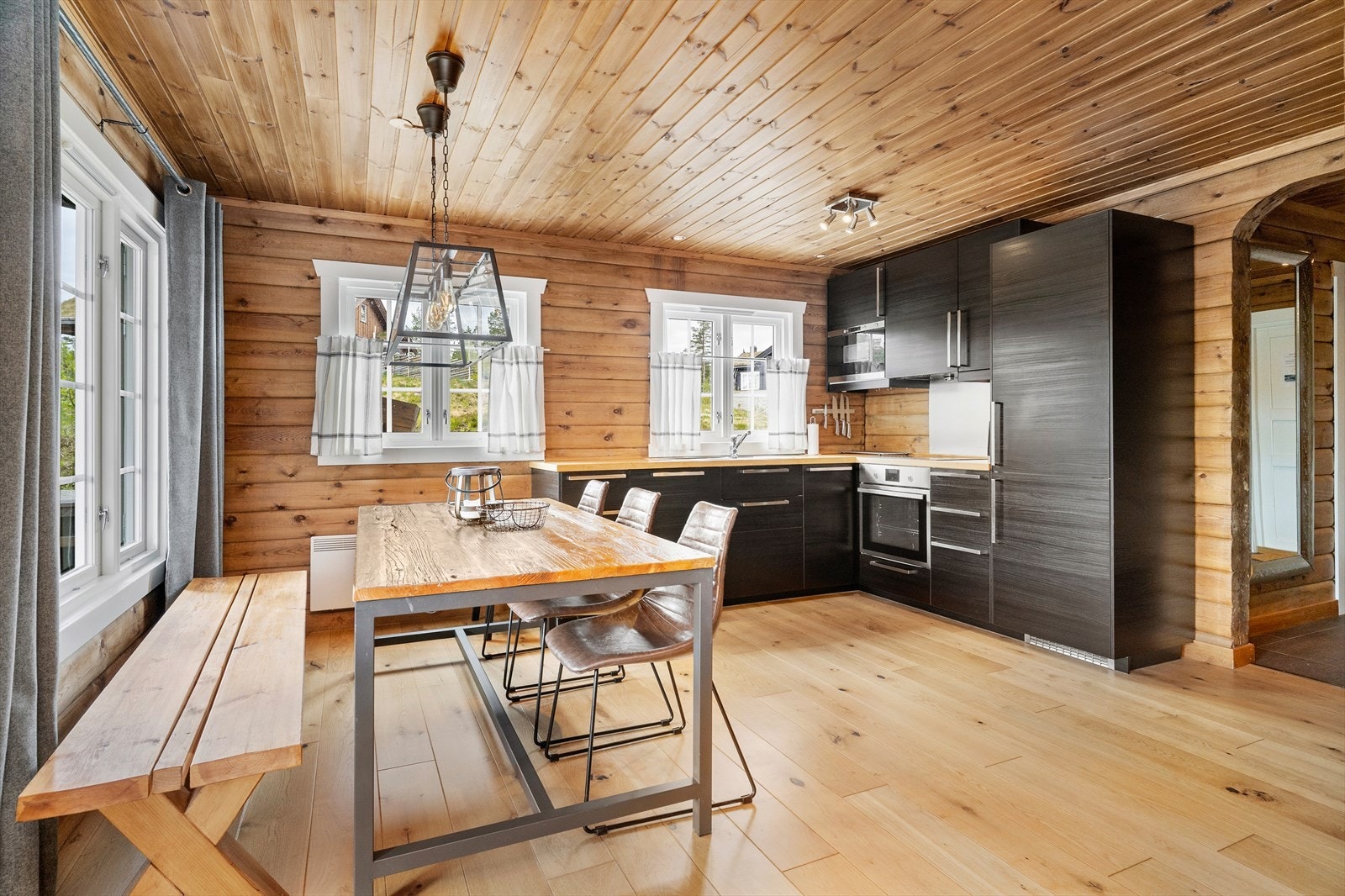 Kjøkkeninnredning med slette lakkerte fronter, med heltre benkeplate, oppvaskkum, ventilator med utluft og integrerte hvitevarer som stekeovn, platetopp, oppvaskmaskin, kjøl/frys. Galleribilde