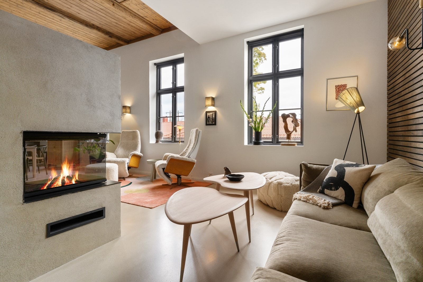 Peis er plassert mellom stue og kjøkkendel og gir et naturlig romskille. Her kan man nyte sene vinterkvelder. Galleribilde