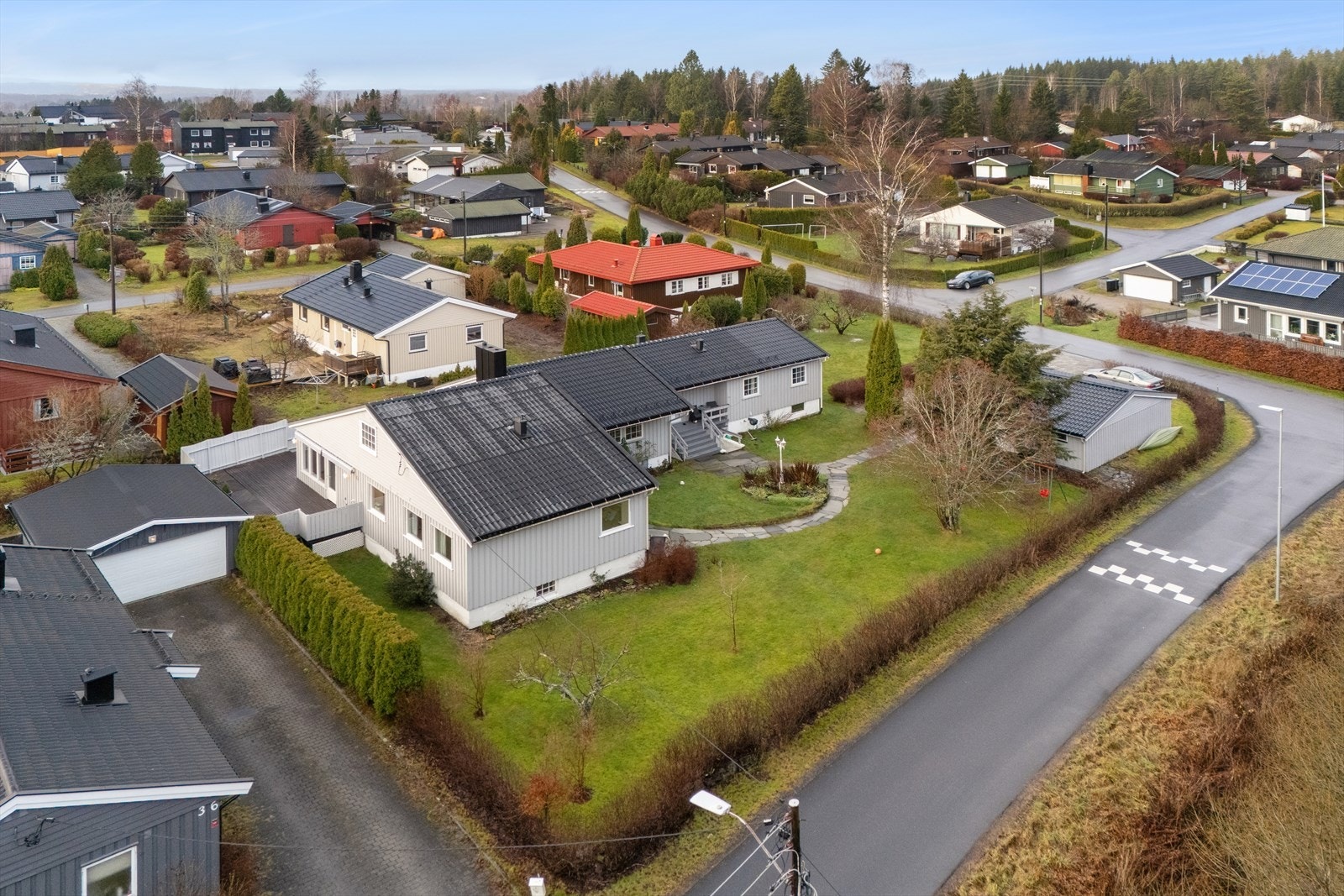 Boligen har en velholdt hage med plen, busker og sittegruppe. Galleribilde