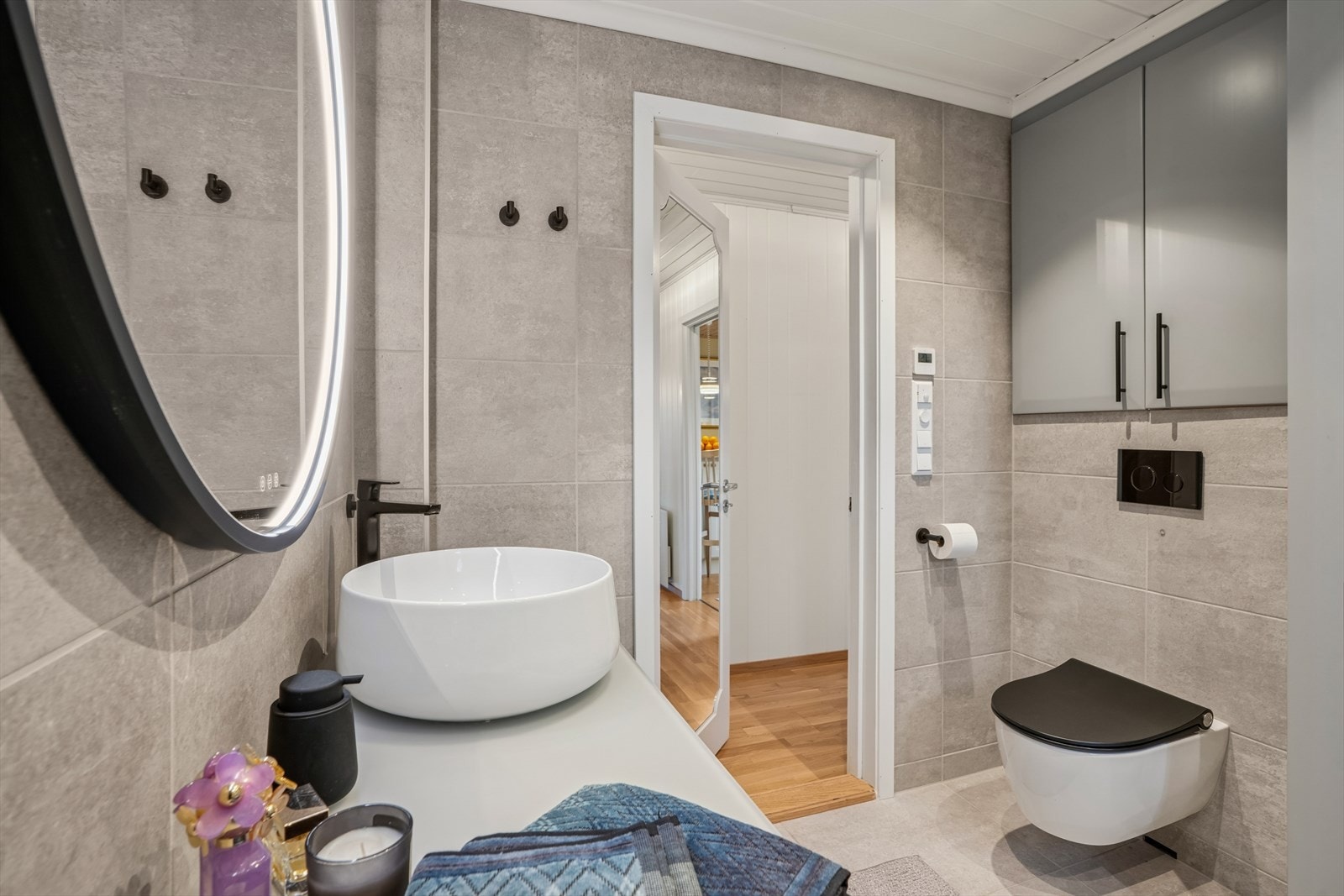 Dette badet har flislagt gulv med behagelig, vannbåren gulvvarme, flislagte vegger og malt panel i himlingen. I Galleribilde