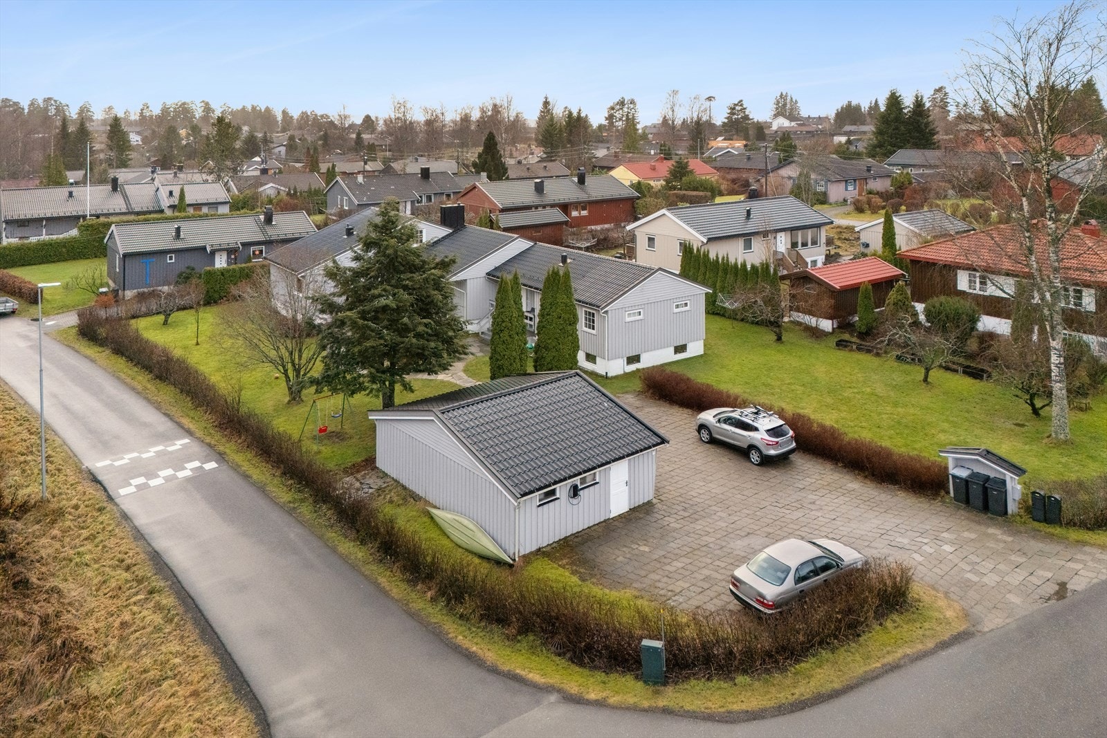 Eiendommen har i tillegg dobbelgarasje (delt med nabo) og hellelagt gårdsplass. Galleribilde