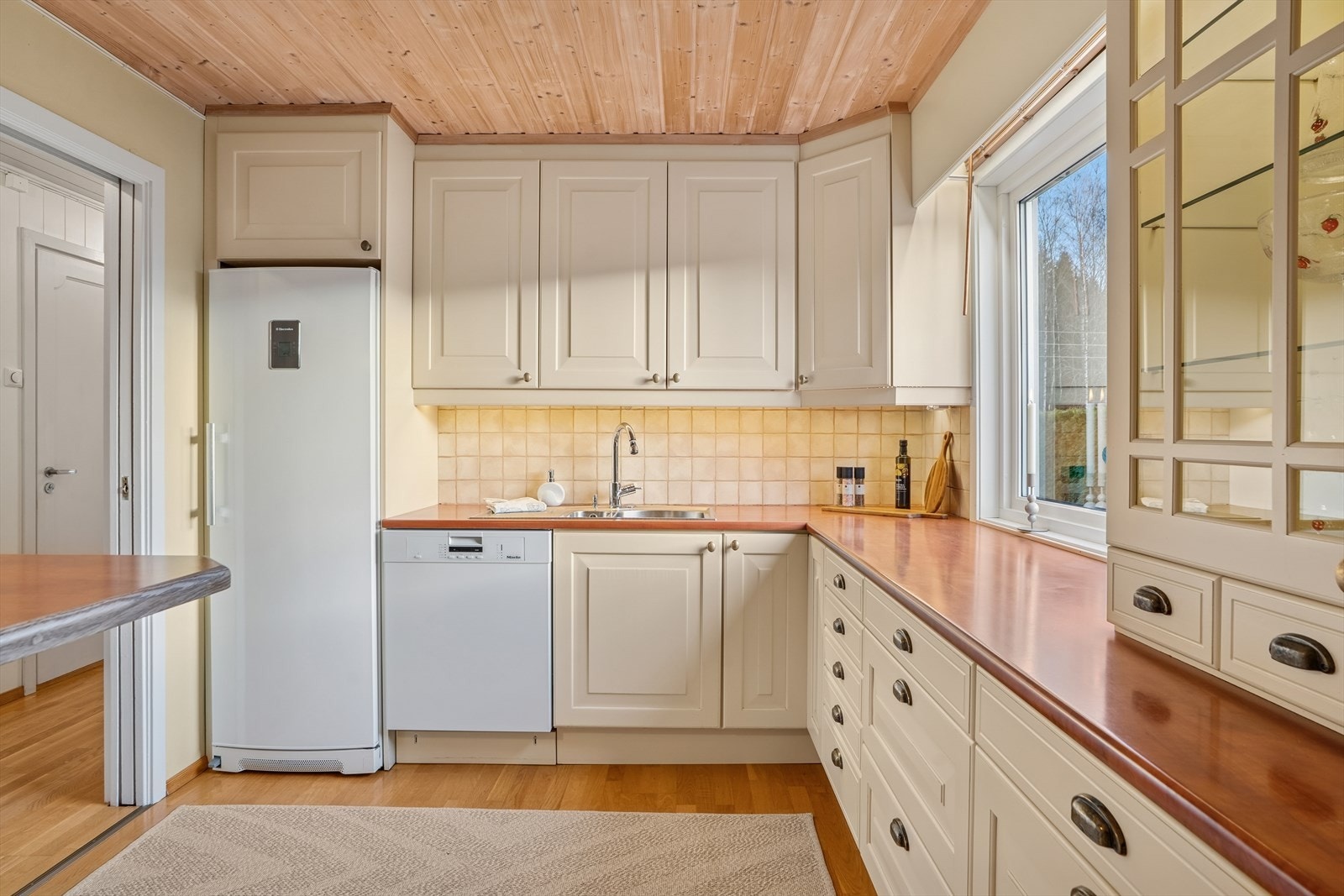 Kjøkkenet er fra 2003 og har en pen, håndlaget innredning fra snekker med lyse, profilerte fronter og laminerte benkeplater med nedfelt oppvaskkum i rustfritt stål. Galleribilde