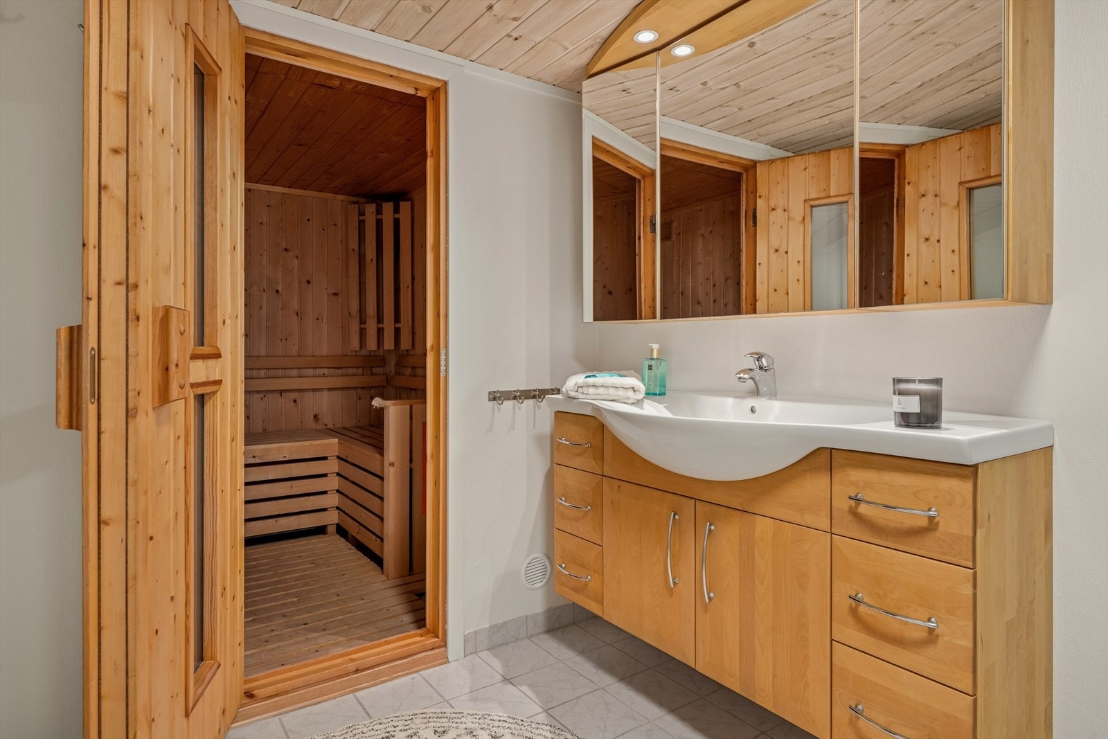 Dette badet er innredet med baderomsinnredning med heldekkende servant og underskap, frittstående toalett og dusjhjørne. Galleribilde