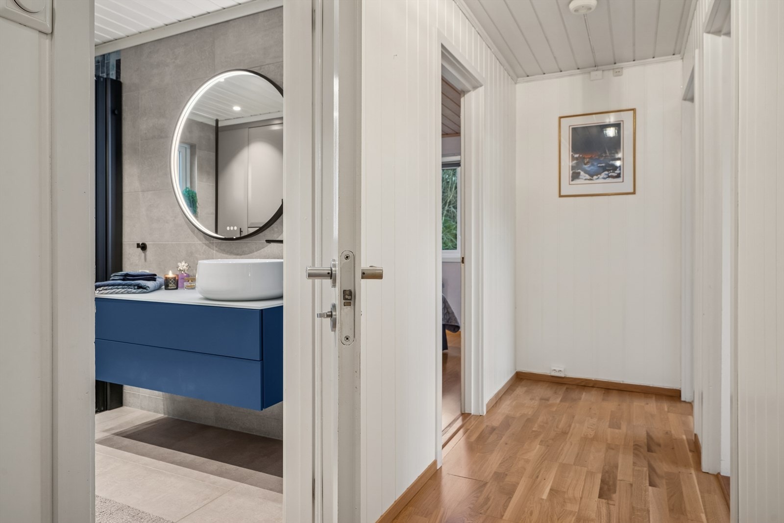 Flislagt bad med moderne innredning og speil gir et stilrent uttrykk. Galleribilde