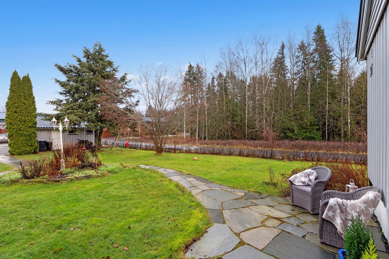 Eiendommen er pent opparbeidet med gressplen, blomsterbed og diverse prydbeplantning. Galleribilde