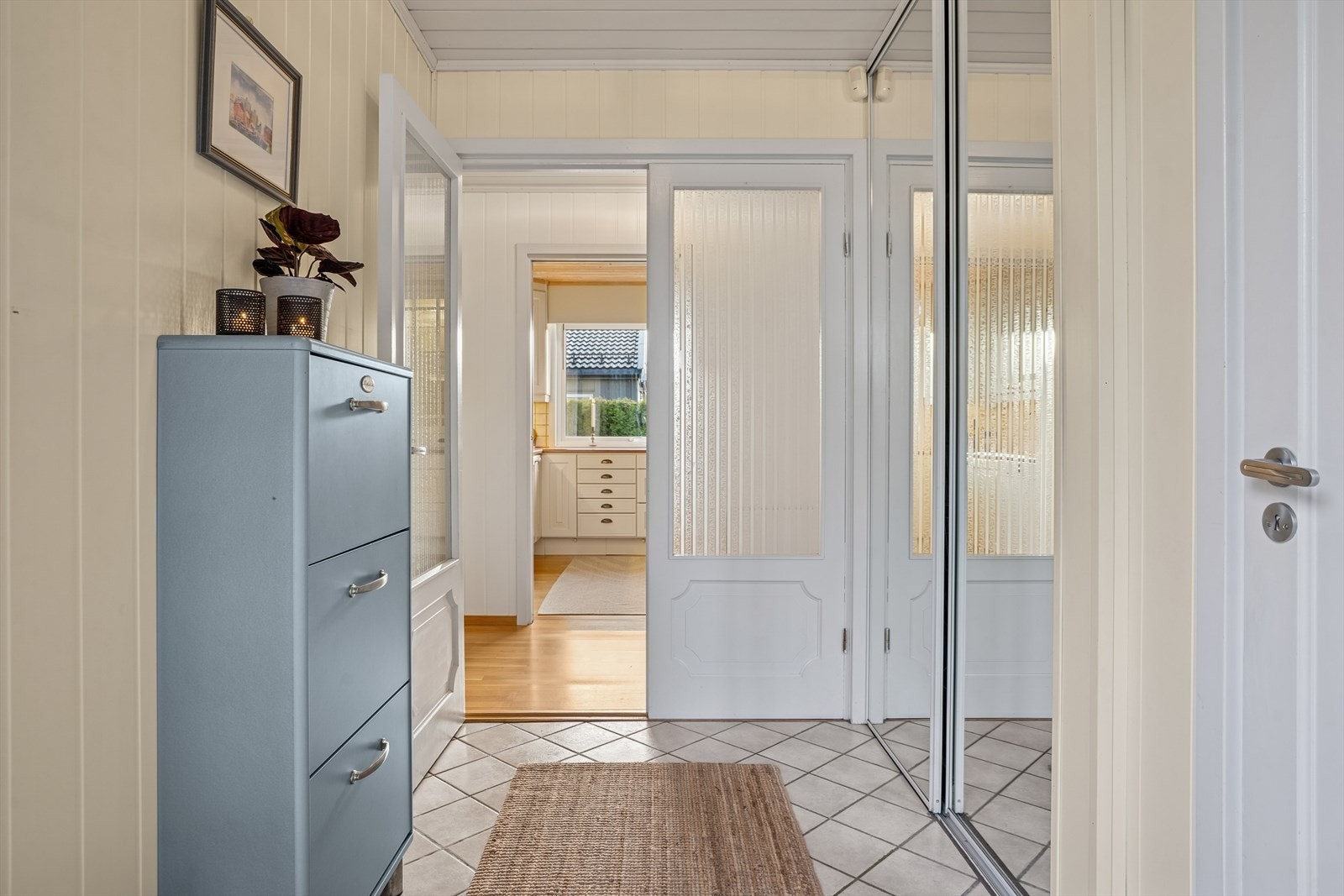 Entréen har flislagt gulv og oppbevaringsplass i skyvedørsgarderobe med speilfronter. Galleribilde