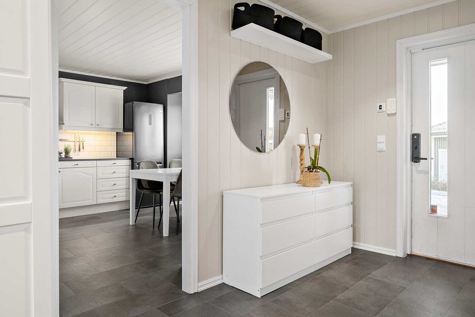 Praktiske fliser med elektrisk gulvvarme som varmer behagelig på kalde morgener, mens panelvegger malt i lyse toner skaper en inviterende atmosfære. Galleribilde