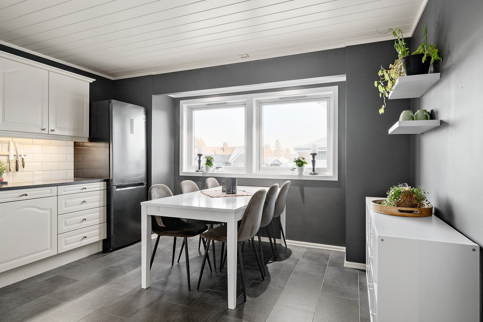 Innredningen er klassisk og tidløs med hvite, profilerte fronter og en laminert benkeplate som gir både arbeidsplass og et rent uttrykk. Galleribilde