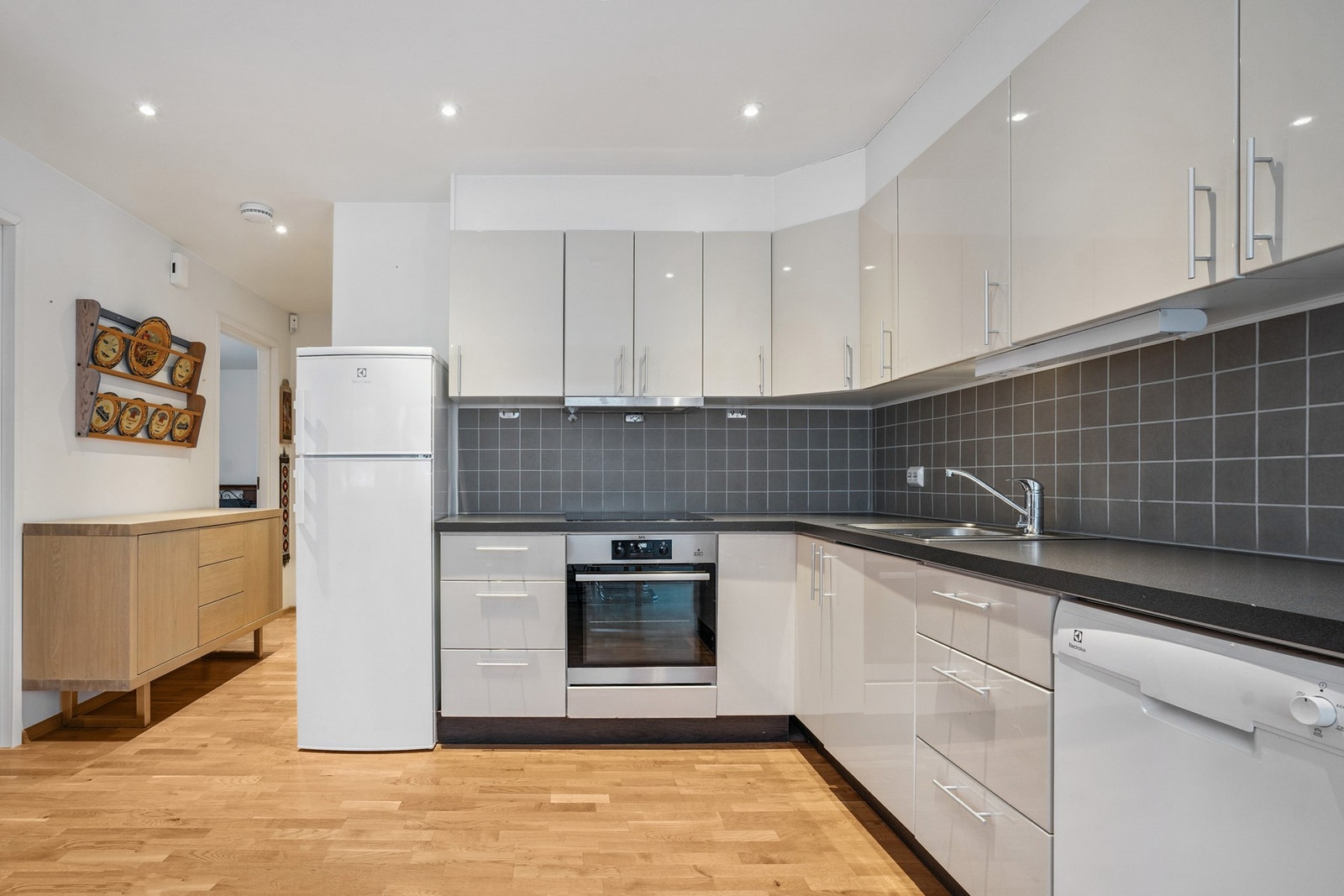 Tidløs kjøkkeninnredning med glatte fronter og laminat benkeplate. Galleribilde