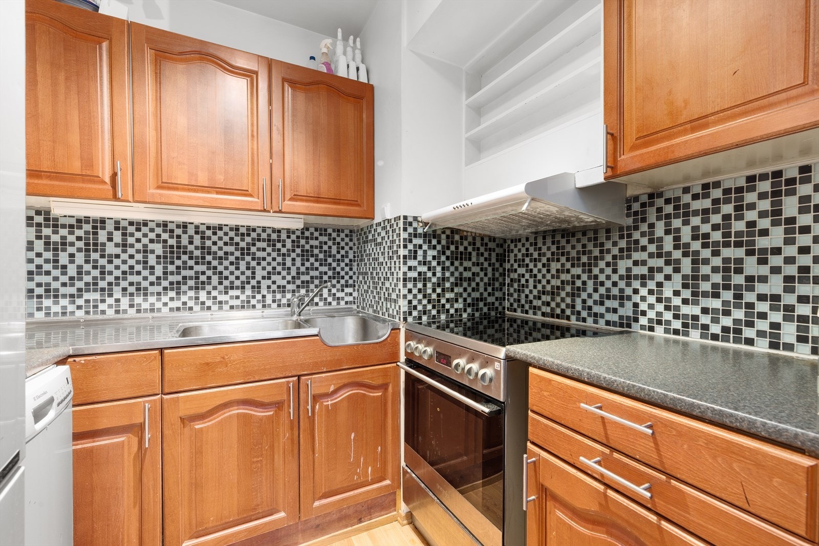 Kjøkkeninnredning fra Sigdal med profilerte fronter og laminat benkeplate. Frittstående hvitevarer. Flislagt vegg over benker for praktisk sprutsikring. Galleribilde