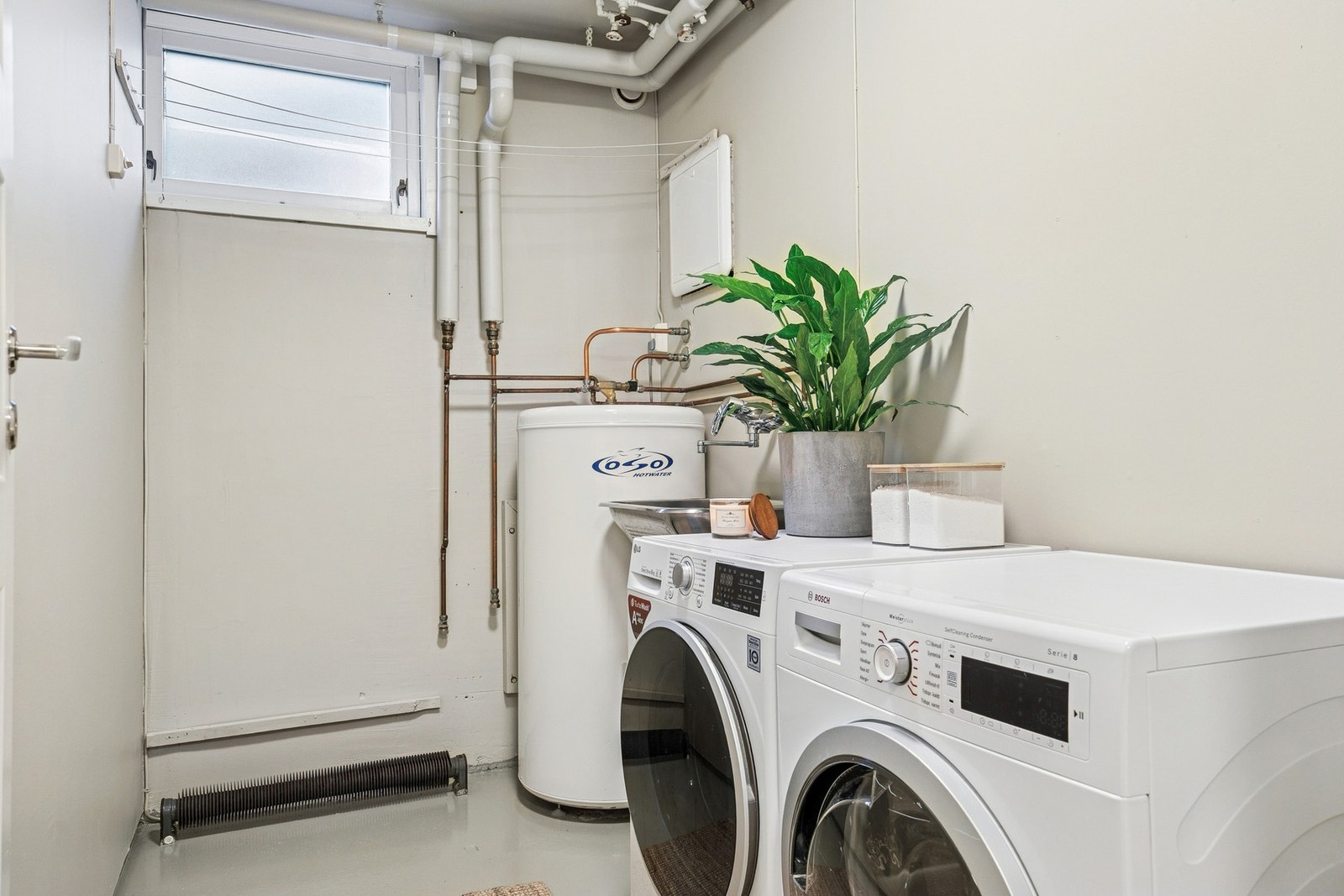 Vaskerommet har malt betonggulv, malte flater, opplegg for vaskemaskin og fordelerskap for rør-i-rør-system. Galleribilde