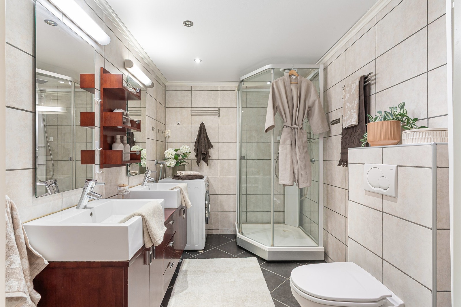 Romslig bad med fliser på gulv og vegger, elektriske varmekabler og god belysning. Galleribilde