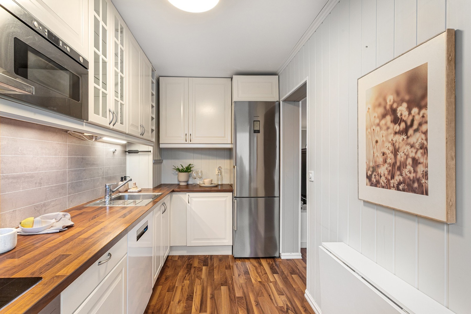 Kjøkkenet har en laminat benkeplate med trestruktur som gir et varmt og tidløst uttrykk, samtidig som den er slitesterk og enkel å vedlikeholde. Galleribilde