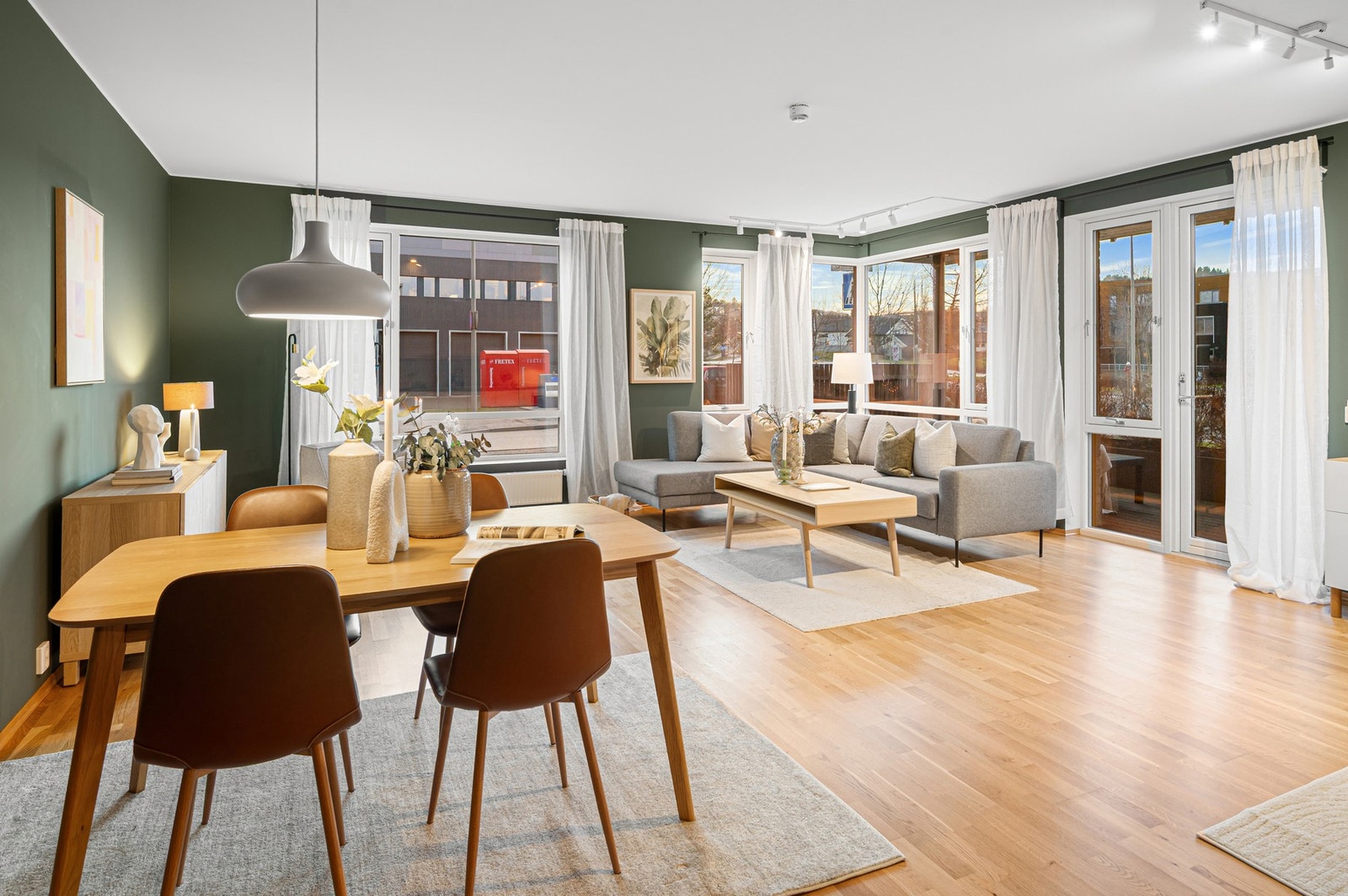 Sosial stue- og kjøkkenløsning med naturlig inndeling mellom spiseplass og sofesone. Galleribilde