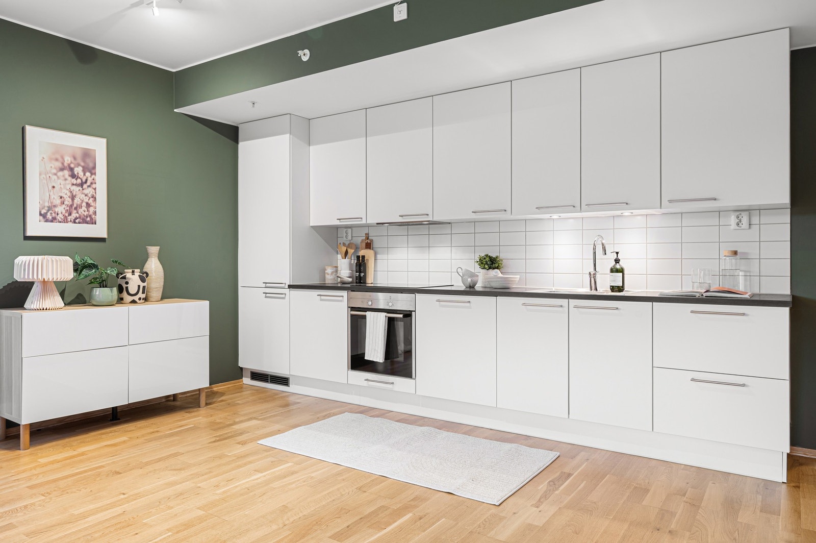 Moderne kjøkken fra byggeår med slette, lyse fronter og integrerte hvitevarer. Galleribilde