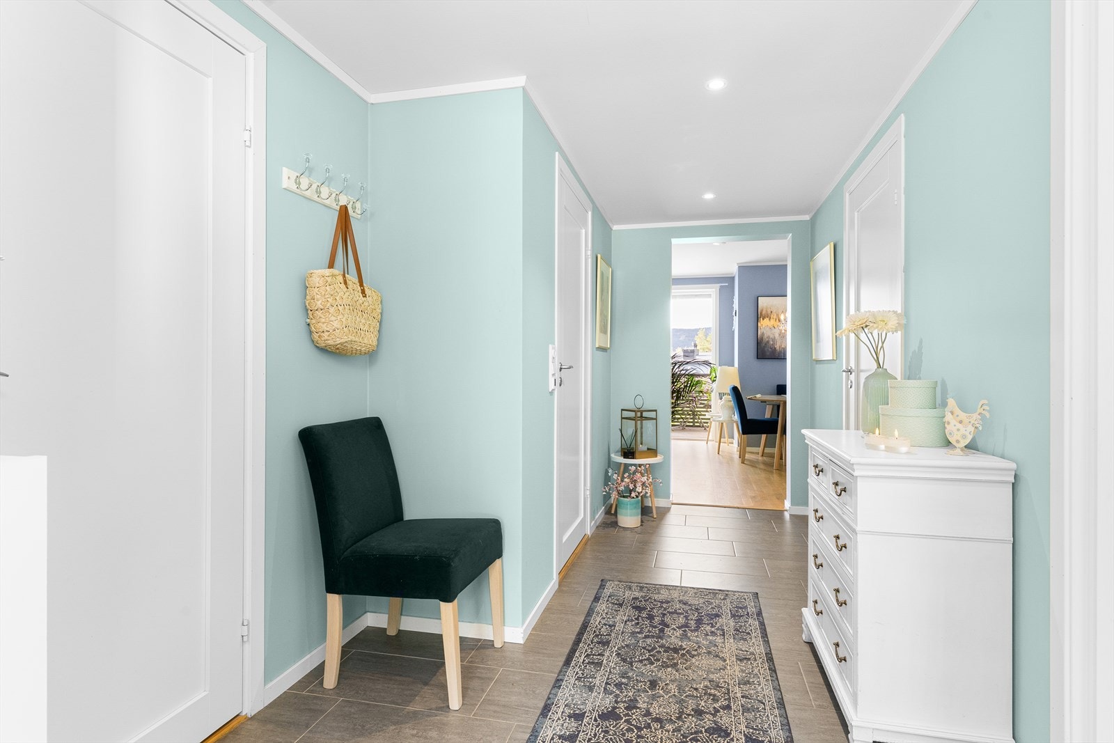 Velkommen inn! Her blir man møtt av en romslig flislagt gang med videre adkomst inn i stue/kjøkken. Galleribilde