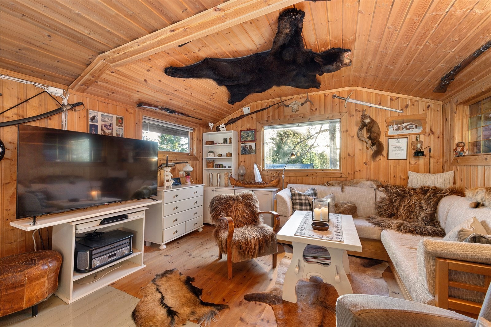 Hytta har en gjennomført og personlig stil med detaljer som gir en helt spesiell atmosfære. I taket henger skinnet fra en svartbjørn opprinnelig fra Canada. På veggen finner du bl.a måren Råger :-) Galleribilde