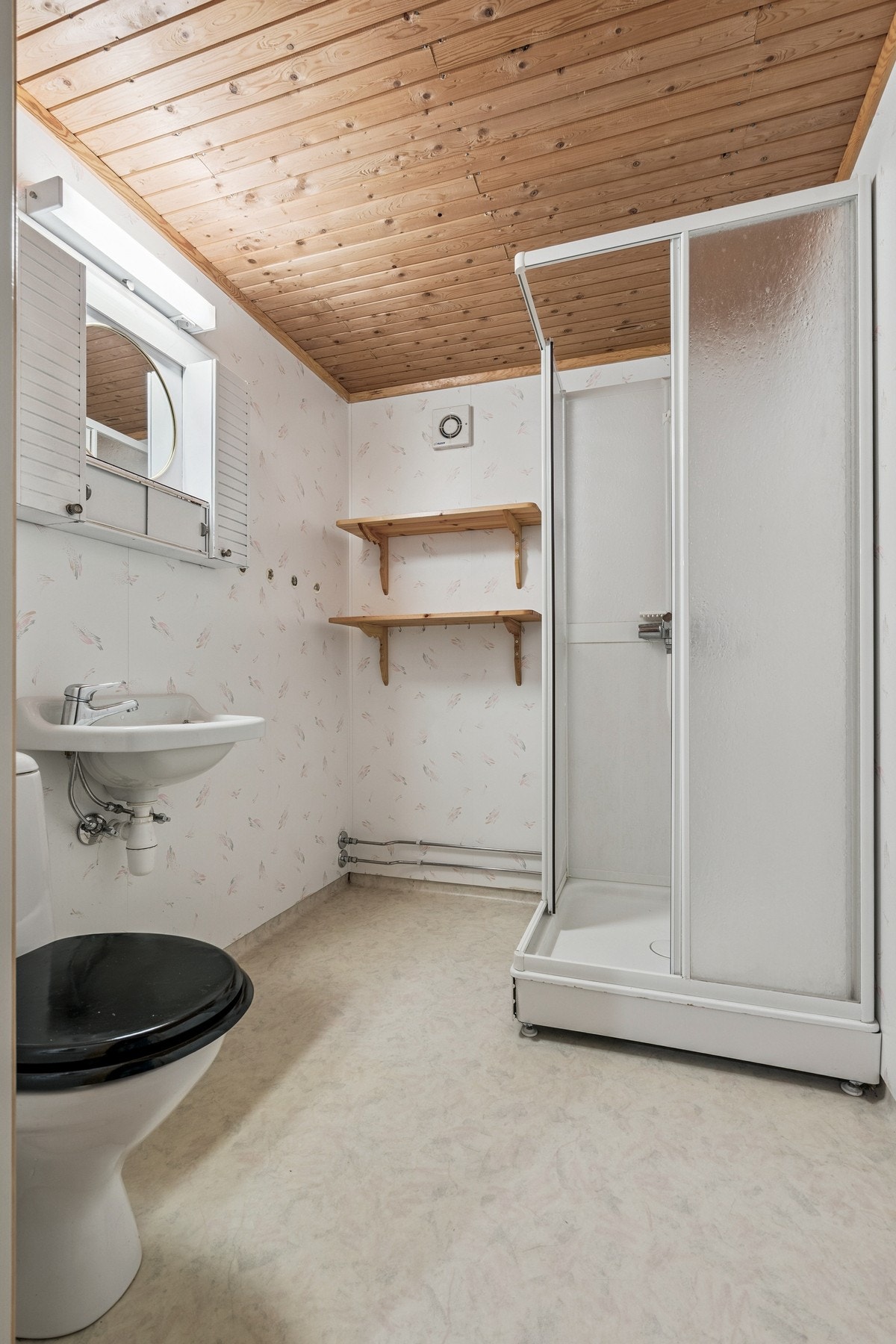 Eldre bad i kjeller med dusjkabinett, toalett og vask. Galleribilde