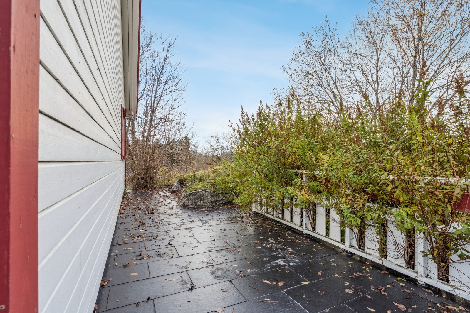 Terrassen er flislagt og strekker seg rundt 2 sider av boligen. Galleribilde