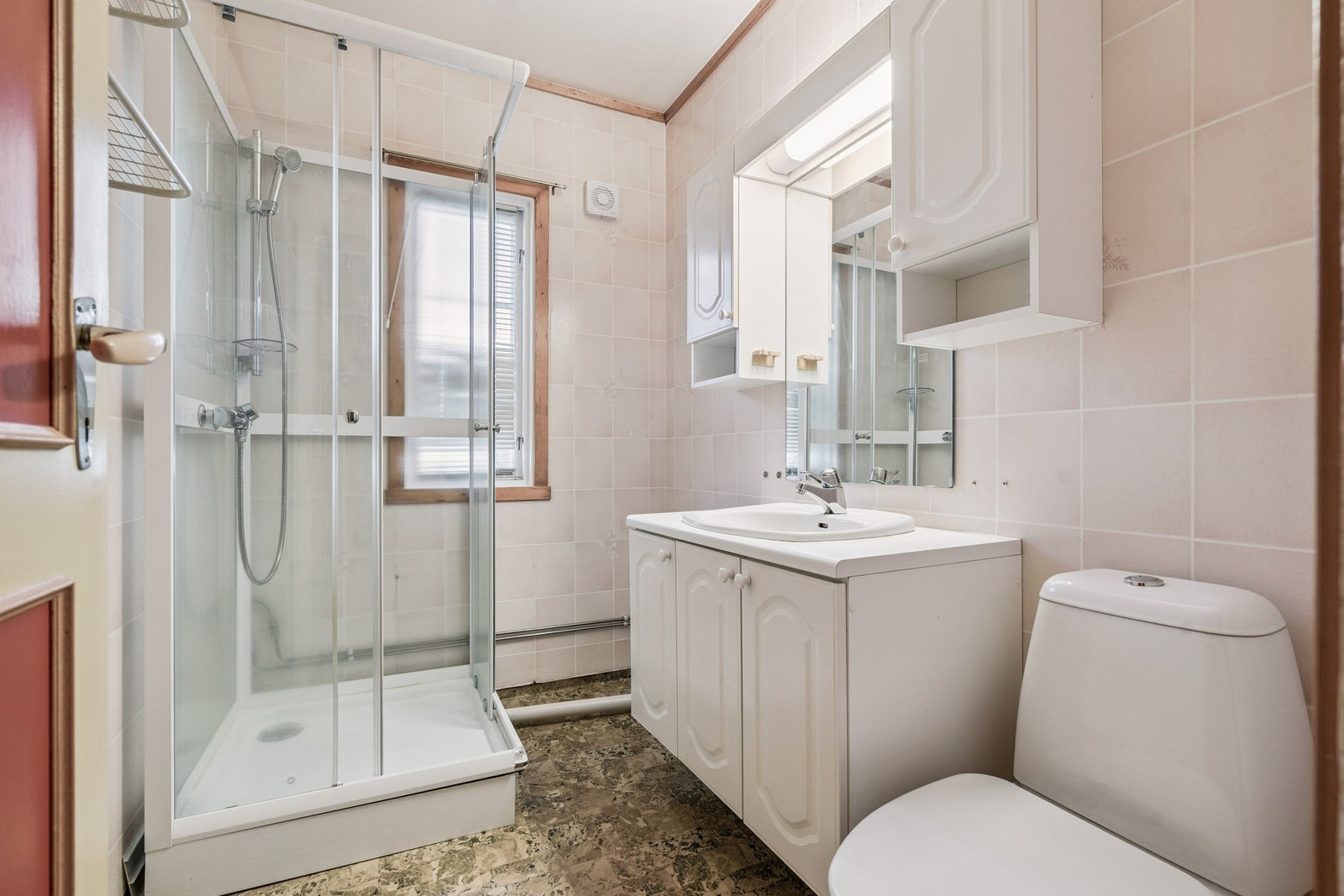 Bad med dusjkabinett, toalett, vask og lys baderomsinnredning. Galleribilde