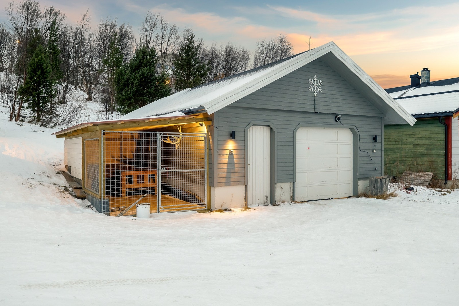Det medfølger en frittstående garasje med hundegård. Galleribilde