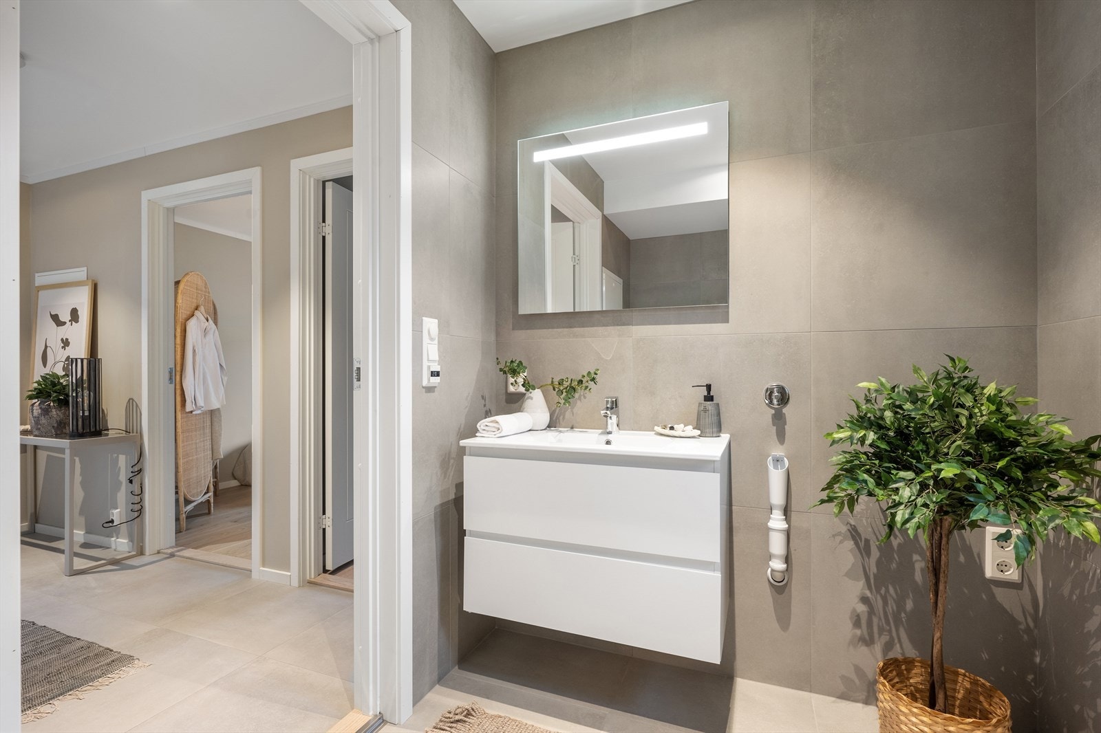 Dagene får en god start på badet, stilrent innredet med store, lysegrå fliser av typen Limestone. Galleribilde