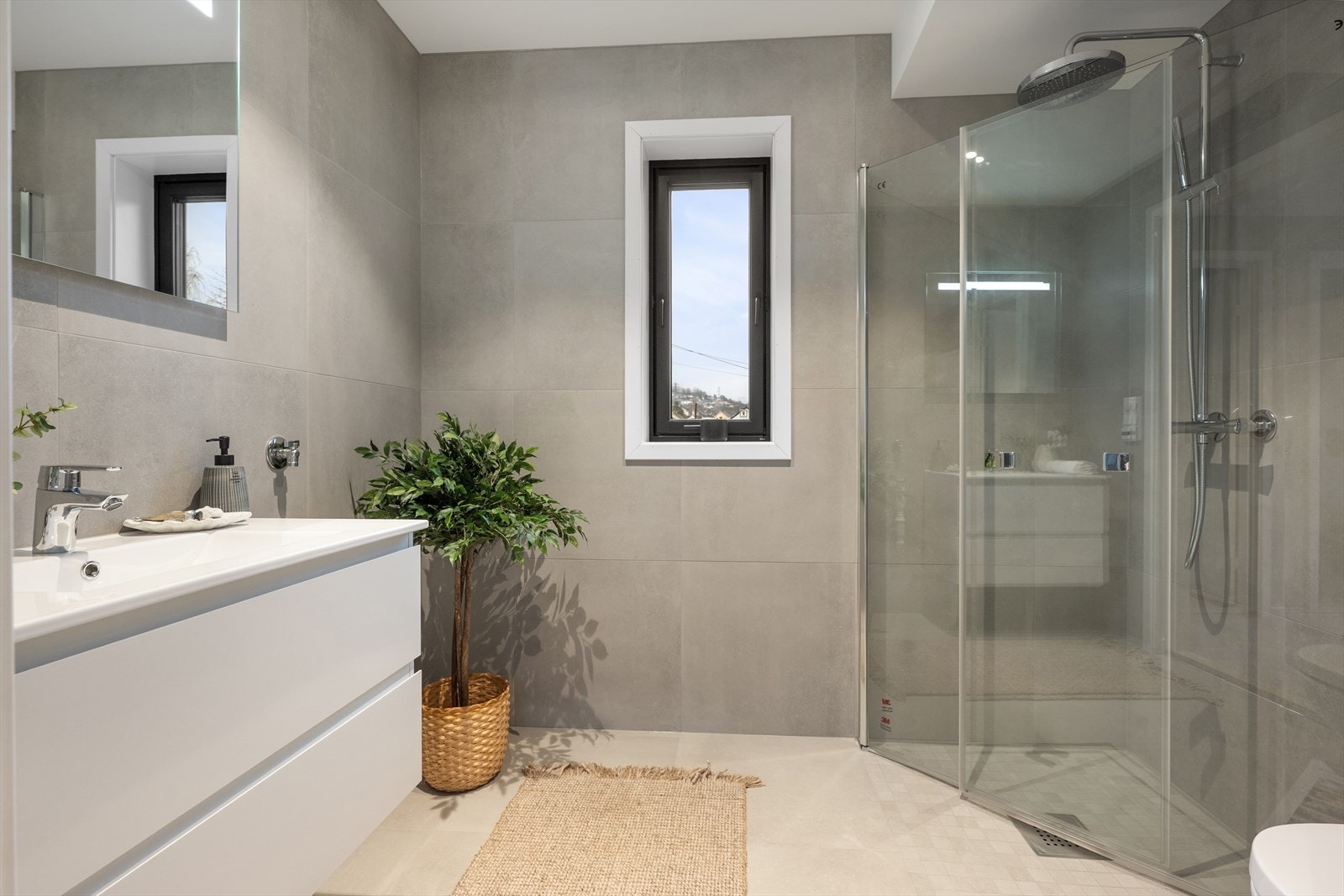 På badet er det varmekabler, vegghengt toalett og dusjhjørne med regnfallsdusj. Galleribilde