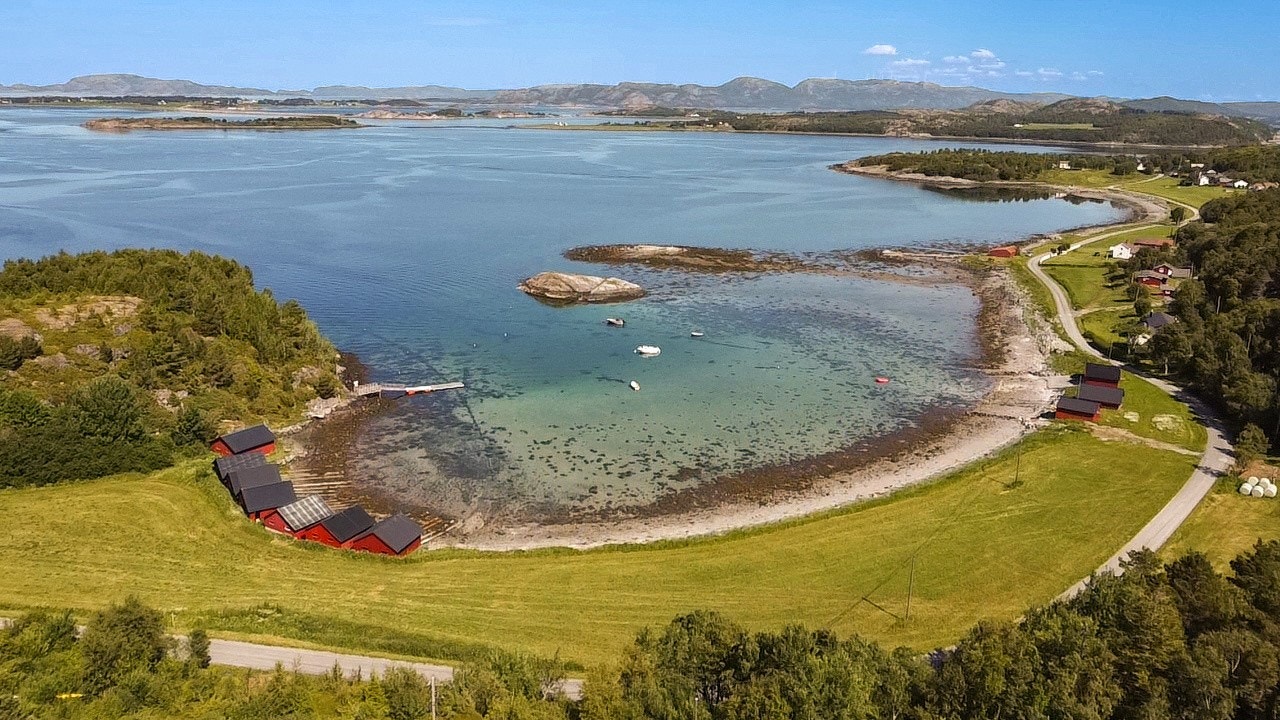 Fra hytta er det kort vei ned til båthuset og stranda. Strandlinjen gir mulighet for bading og båtliv. Galleribilde