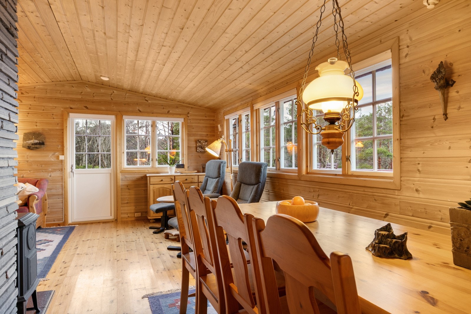 Store vindusflater gir utsyn mot hageområde og skaper en lys atmosfære. Galleribilde