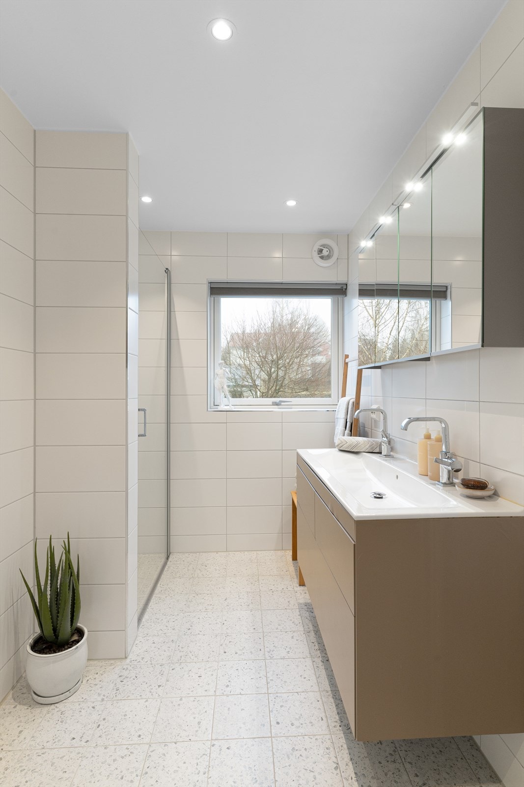 Moderne innredning med dobbel vask og skuffer. Overskap med speil og lys. Galleribilde