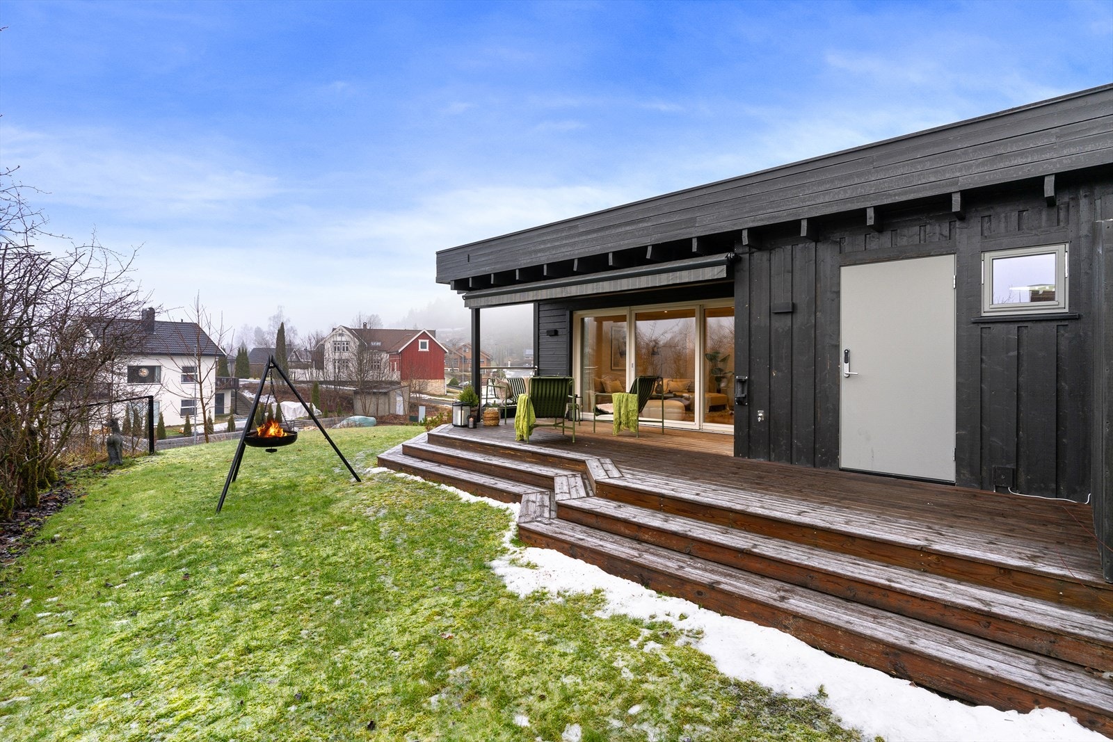 Romslig uteplass, delvis under tak med markise. Plen og uteareal. Galleribilde