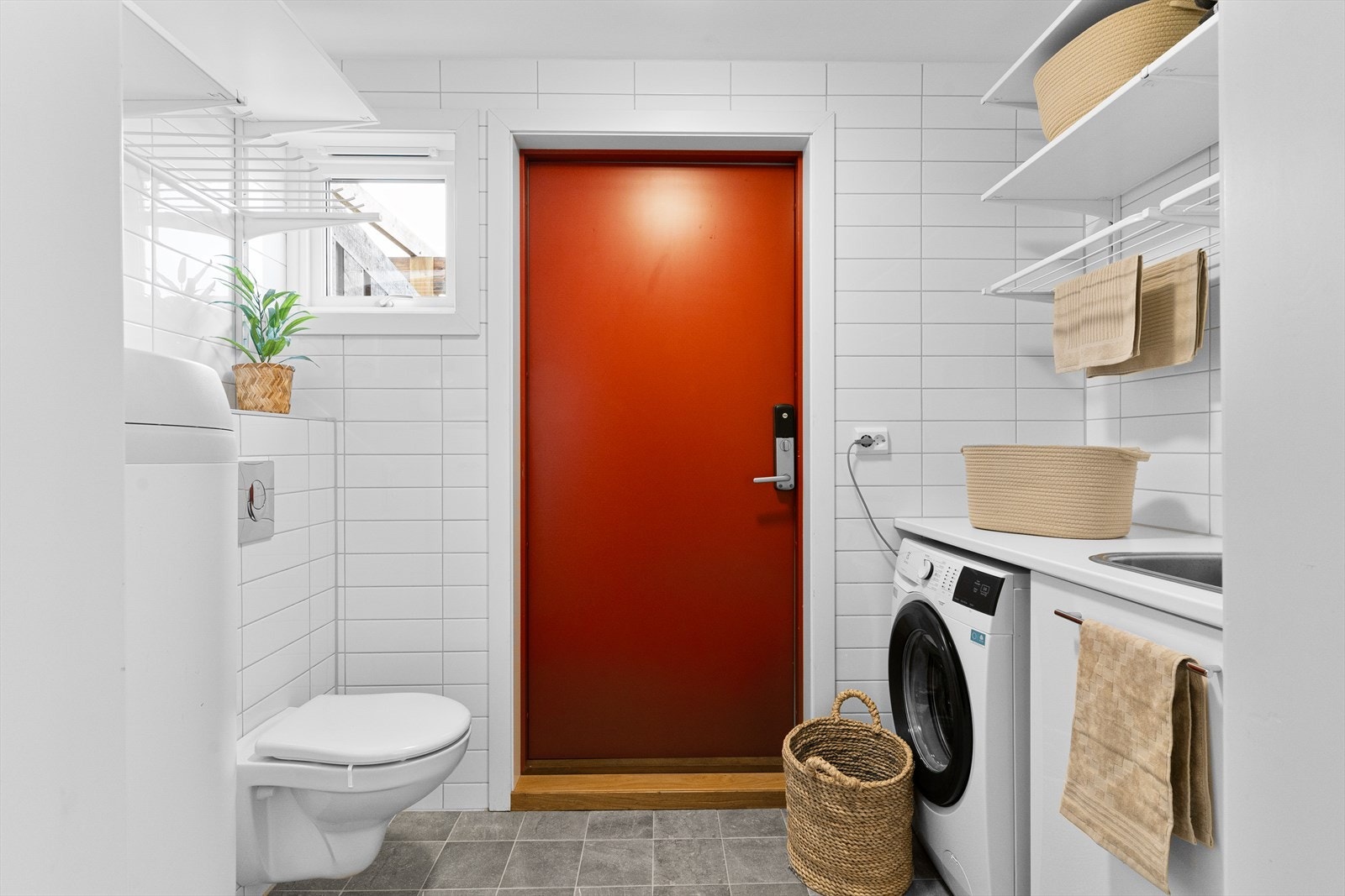 Vaskerom med utgangsdør og vegghengt toalett. Galleribilde