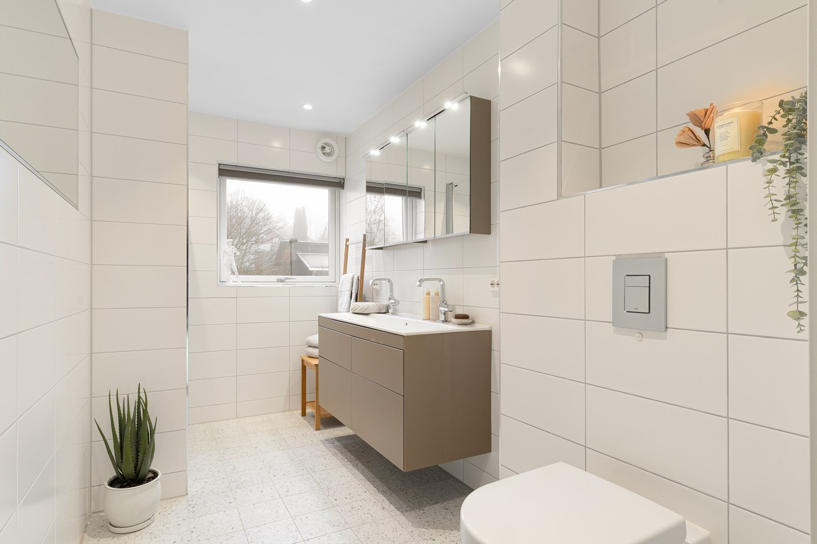 Pent flislagt bad med varmekabler i gulvet. Vegghengt toalett og moderne innredning. Galleribilde