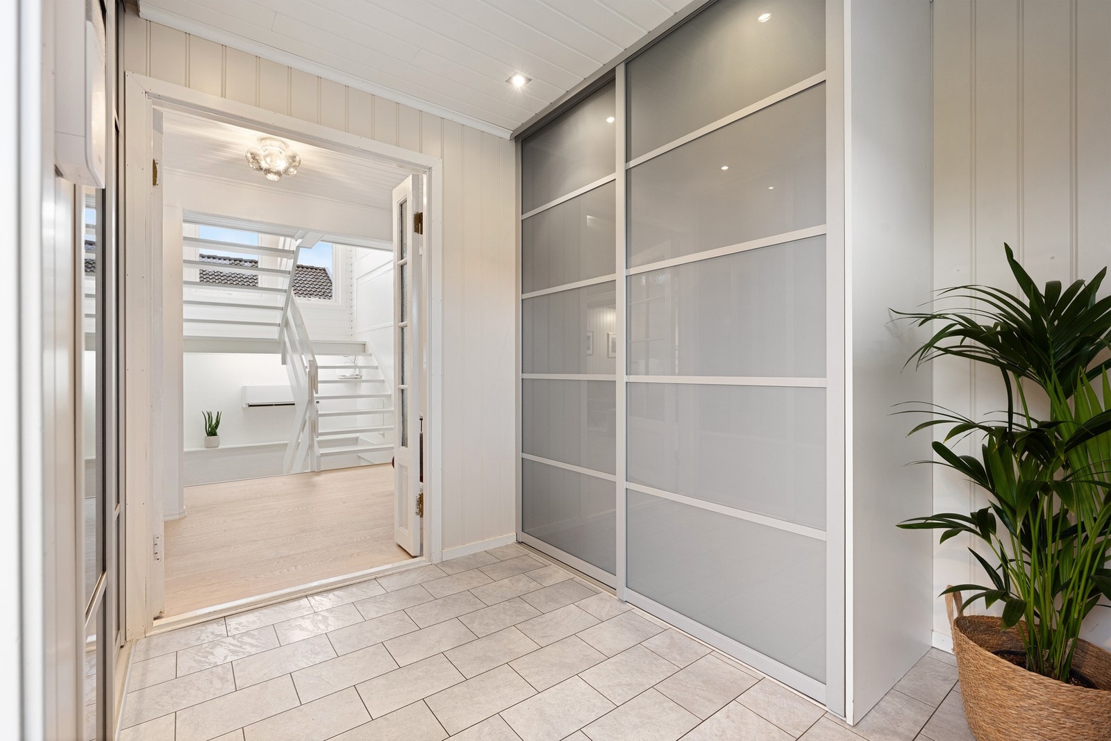 Velkommen inn, entré med garderobe fører videre inn i en større gang Galleribilde