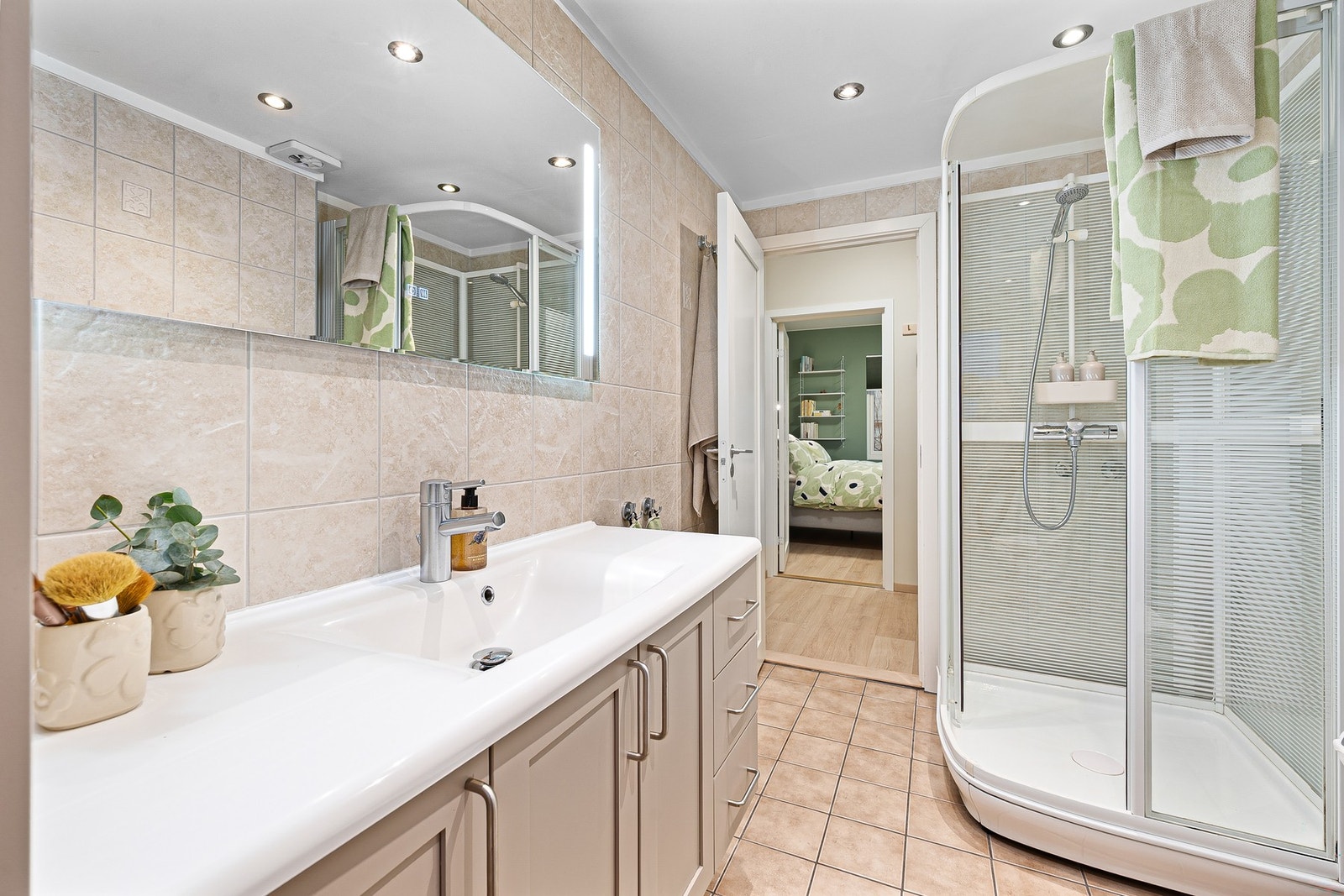 Pent bad med tidløse fliser, servant med underskap og dusjkabinett. Galleribilde