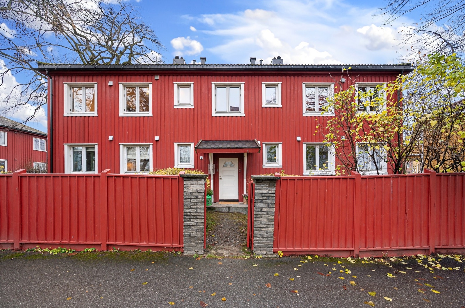 Innbydende fasade med skjermet adkomst og pent inngjerdet uteområde mot gate. Galleribilde