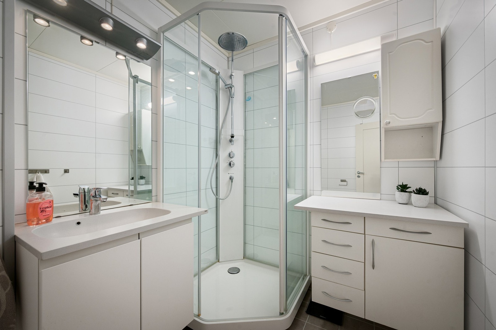 Rommet inneholder praktiske og vegghengte innredninger, toalett og dusjkabinett med regndusj Galleribilde