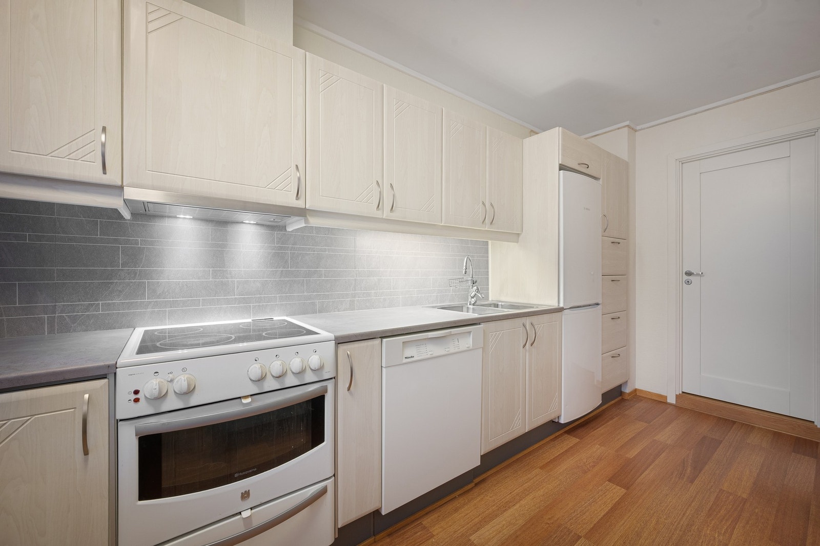 Innredning i klassisk stil med lyse, profilerte fronter og laminert benkeplate Galleribilde