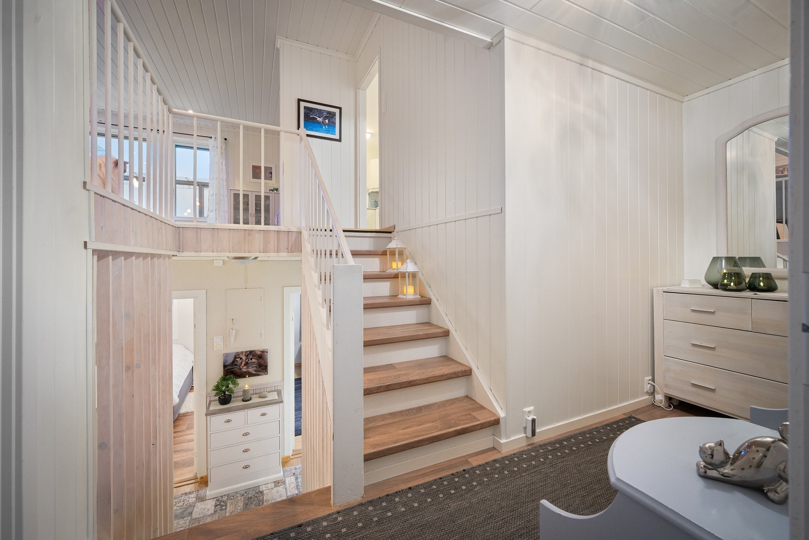 Noen få trappetrinn ned finner vi gang, entré og et soverom Galleribilde