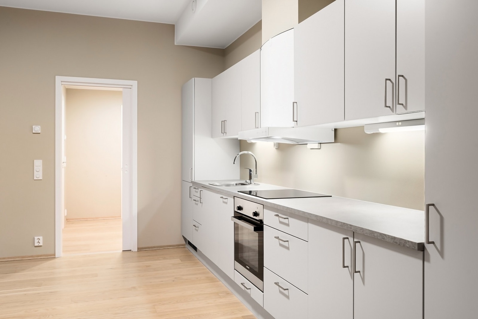 Kjøkkenet inneholder integrerte hvitevarer som platetopp, stekeovn, oppvaskmaskin og kjøl/fryseskap. Galleribilde