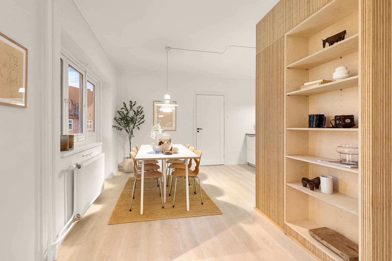 Fra stuen har du også en seksjon med meget flotte plassbyggede hyller som gir en naturlig overgang mellom stuen og spisestue/kjøkken. Galleribilde